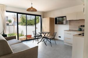 a kitchen and living room with a table and chairs at Villa Lagoon in Carnon-Plage