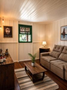 a living room with a couch and a table at Canto da cascata in Gramado