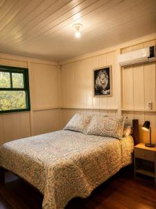 a bedroom with a bed and a window at Canto da cascata in Gramado