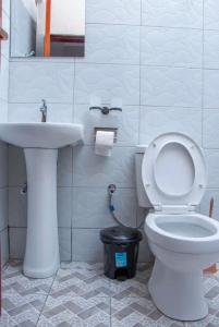 a bathroom with a white toilet and a sink at Gugga Suites Mbale in Mbale