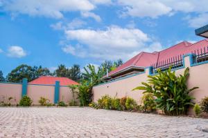 a building with a red roof and a brick driveway at Gugga Suites Mbale in Mbale