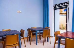 a dining room with tables and chairs and a window at Gugga Suites Mbale in Mbale