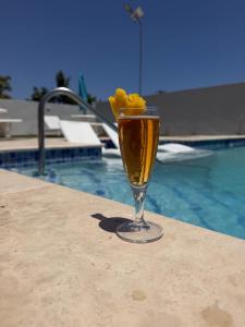 a drink in a glass next to a swimming pool at Coral House - Luxury 3BR Villa - Private Pool - 30 min from MBJ Airport! in Falmouth