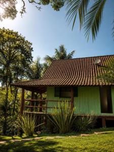 a green house with a brown roof at Canto da cascata in Gramado