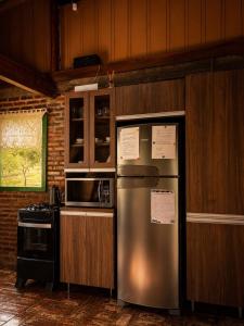 a kitchen with a stainless steel refrigerator and a stove at Canto da cascata in Gramado