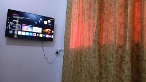 a tv hanging on a wall next to a curtain at Al-Ahmari Holiday Apartment in Mogadishu