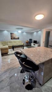 a kitchen with a counter and bar stools in a living room at sweet home in Nemila