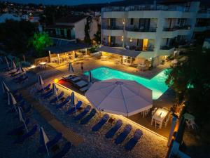 Draufsicht auf ein Schwimmbad mit Sonnenschirmen und einem Gebäude in der Unterkunft Lido Hotel in Xylokastro