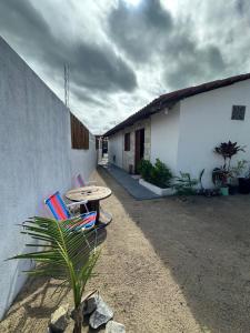 a patio with a table and chairs next to a building at Maruva Chalé in Aquiraz