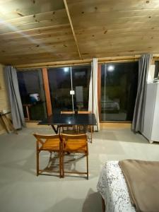 a room with a table and a bench and windows at Chalés Mar & Mata Paraty in Paraty