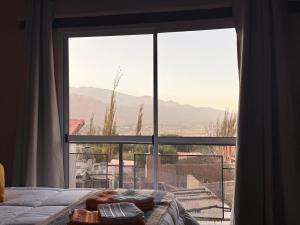 a bedroom with a large window looking out at the mountains at Usina Elias in Tilcara