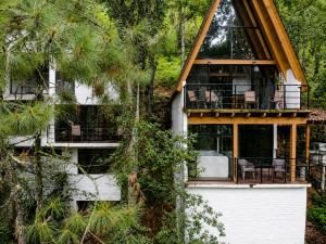 a house with a wrap around porch with chairs on it at Cabaña sueño real in Mazamitla