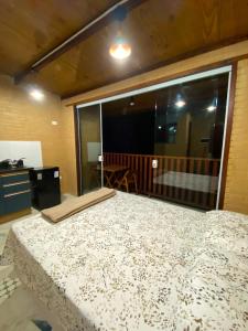 a bedroom with a large bed and a large window at Chalés Mar & Mata Paraty in Paraty +7 photos