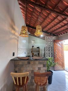 a kitchen with two chairs and a counter with two lights at Maruva Chalé in Aquiraz