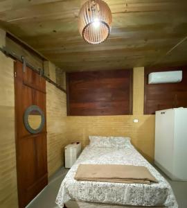 a bedroom with a bed and a chandelier at Chalés Mar & Mata Paraty in Paraty