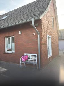 a bench with flowers on it in front of a brick building at Landglück in Ibbenbüren