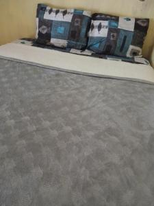 a bed with a gray mattress with pillows on it at Aldea Axocobaca in Zoquitlán +17 photos