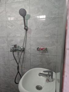a shower in a bathroom with a toilet and a sink at Nandyowa Guesthouse in Kampala +8 photos