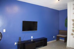 a blue room with a tv on a blue wall at APT térreo completo - 2 Quartos - 2 Ar-condicionados, Cozinha, Garagem, WI-FI- Maurício Nassau, Perto de tudo in Caruaru