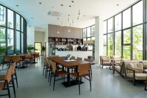 a restaurant with tables and chairs and a bar at New Capri Condo in Bang Tao by Lofty in Ban Thalat Choeng Thale