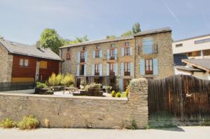 a building with a stone wall and a fence at Lodge Les Cariolettes in Font-Romeu-Odeillo-Via