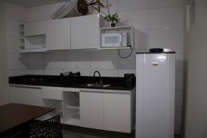 a small kitchen with a sink and a refrigerator at APT térreo completo - 2 Quartos - 2 Ar-condicionados, Cozinha, Garagem, WI-FI- Maurício Nassau, Perto de tudo in Caruaru +35 photos