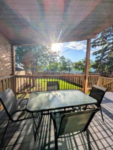 a patio with a table and chairs on a deck at Mountview Maison in Red Deer