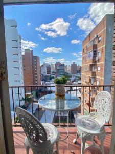 a table and chairs on a balcony with a view of a city at Departamento zona sur 1 dormitorio in Santa Fe