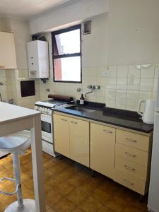 a kitchen with a sink and a stove at Departamento zona sur 1 dormitorio in Santa Fe