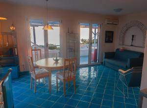 a living room with a table and chairs and a couch at Villa Azul - A Timeless Retreat Above the Aegean in Alonnisos