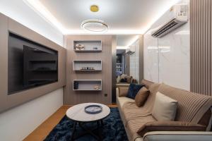 a living room with a couch and a tv at New Capri Condo in Bang Tao by Lofty in Ban Thalat Choeng Thale