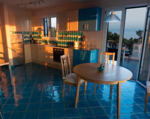 a kitchen with a table and chairs in a room at Villa Azul - A Timeless Retreat Above the Aegean in Alonnisos