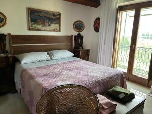 a bedroom with a bed with a purple blanket and a window at Toni's in Pianillo