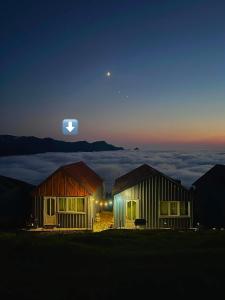 two houses on top of a mountain at night at Gomismta Golden Hour Cottages in Gomi