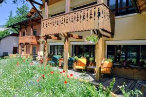 a building with a patio with chairs and flowers at Abries Hôtel in Abriès