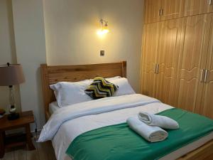 a bedroom with a bed with towels on it at Floma Homes in Nairobi