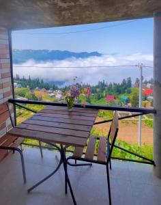 a balcony with a wooden bench and a large window at Gomismta Golden Hour Cottages in Gomi