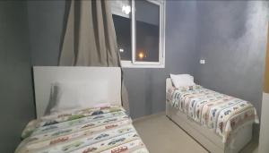 a small bedroom with a bed and a window at Tanger plage Al Houara in Tangier