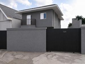 a house with a black fence and a gate at Refúgio dos ventos in Campos do Jordão
