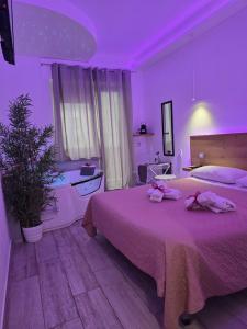 a bedroom with a large bed with pink lighting at Il Mare di Roma Deluxe in Lido di Ostia +76 photos