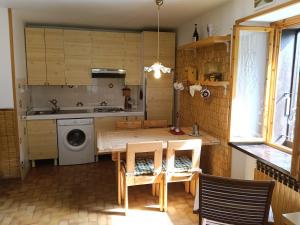 a kitchen with a table and chairs and a washing machine at Il gallo alpino a Champorcher in Champorcher +12 photos