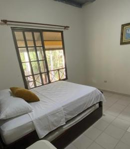 a bedroom with a large bed with a window at The Mexican in Los Altos de Cerro Azul