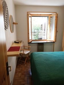 a bedroom with a bed and a window and a desk at Il gallo alpino a Champorcher in Champorcher