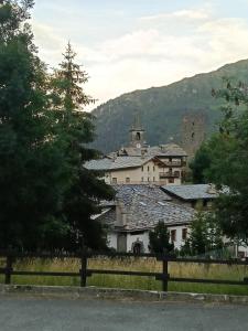 a large white building with a tower on a hill at Il gallo alpino a Champorcher in Champorcher