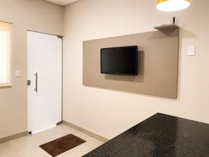 a room with a flat screen tv on the wall at Vêneto Flat Residence (AP-02) in Primavera do Leste