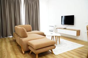 a living room with a chair and a tv at Corner Apartments in Tirana