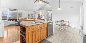 a large kitchen with a sink and a table at Cue & couch retreat in Dieppe