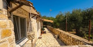 a stone building with a fence next to a yard at Casa Rapata in Gaios
