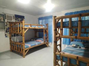 two bunk beds in a room with blue curtains at SJ Transient House in San Fernando +19 photos