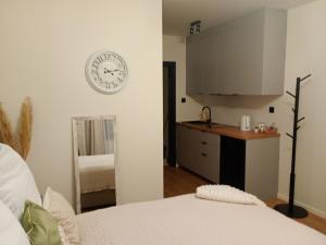 a bedroom with a clock on the wall and a kitchen at Palomino pokoje agroturystyka in Świnoujście +21 photos